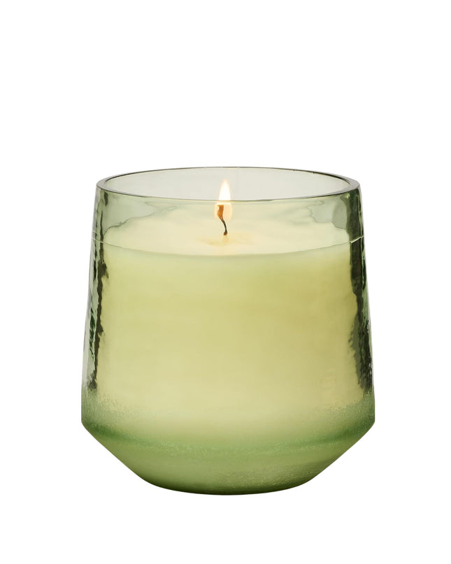 Green candle in a glass holder on a white background