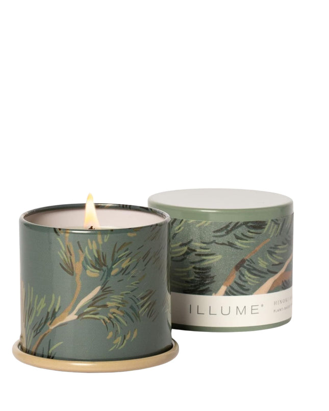 Two candles with leaf patterns on a white background, one lit.