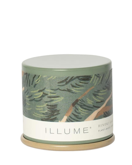 Candle with a leaf pattern and 'ILLUME' branding on a white background