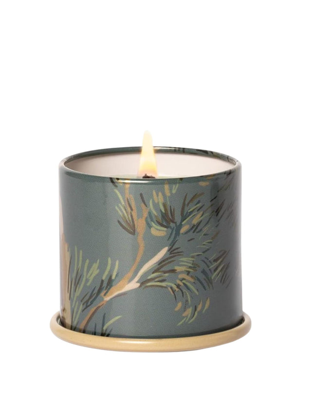 Candle in a decorative tin with floral design on a white background
