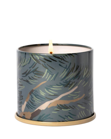 Candle in a decorative container with leaf pattern on a white background