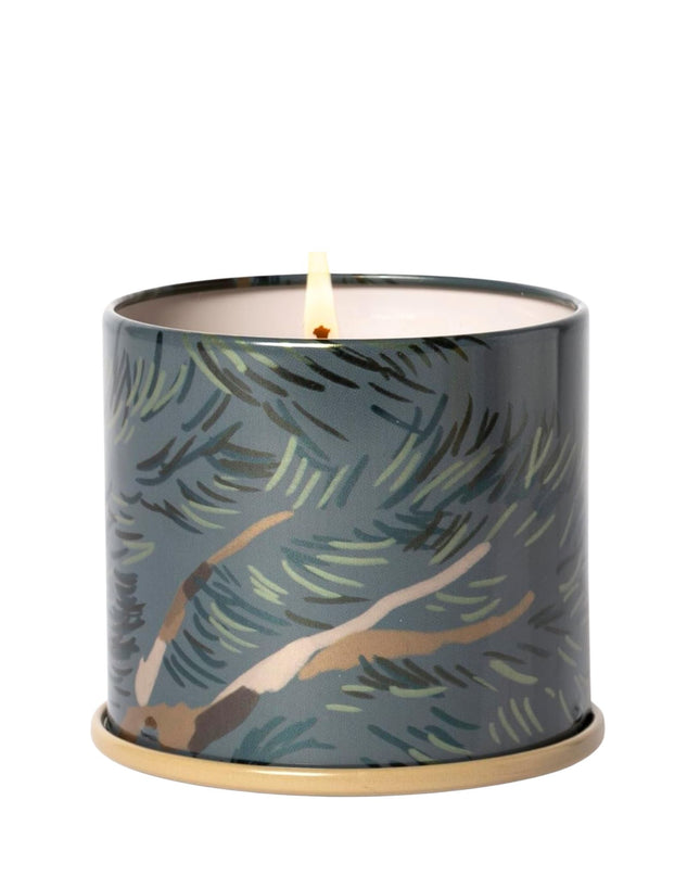 Candle in a decorative container with leaf pattern on a white background