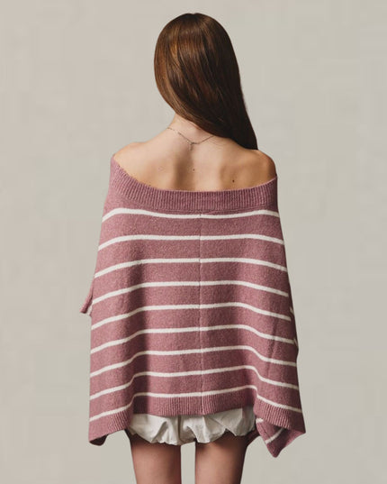A woman viewed from behind wearing an off-the-shoulder, loose-fit knit sweater with horizontal dusty rose and white stripes, paired with white ruffled shorts, against a plain light gray background.