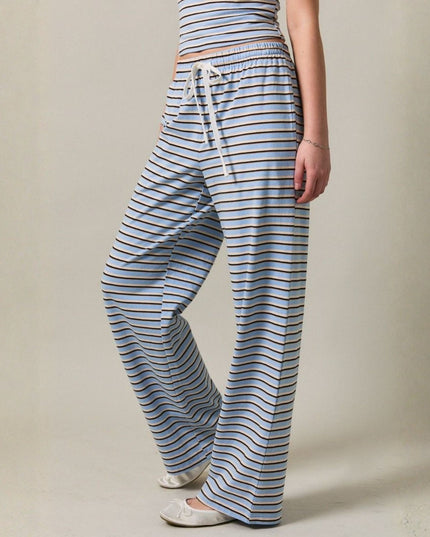 Person wearing blue and white striped pants on a beige background