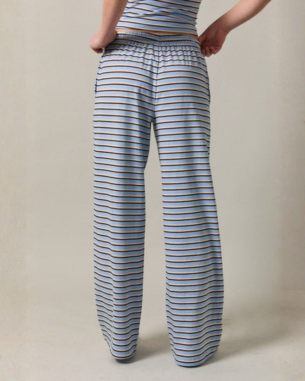 Person wearing blue and white striped pants on a beige background