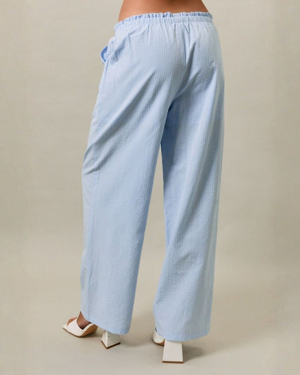 Light blue checkered pants worn by a person on a beige background