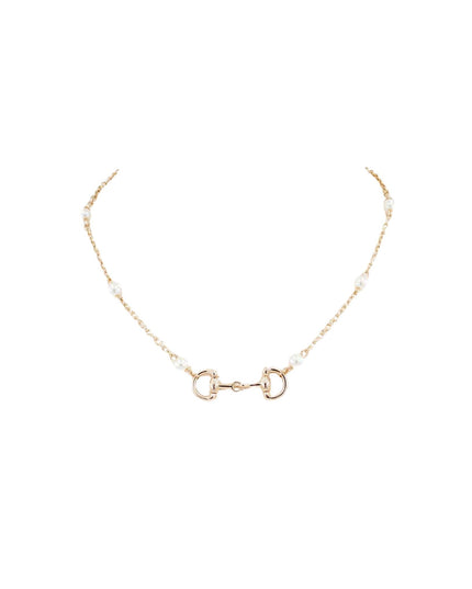 A delicate gold chain necklace featuring a central horsebit clasp and small white pearl beads spaced along the chain, displayed on a solid white background.