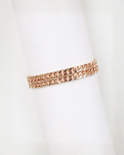 A double-row rose gold curb link bracelet displayed on a white cylindrical mannequin arm against a white background.