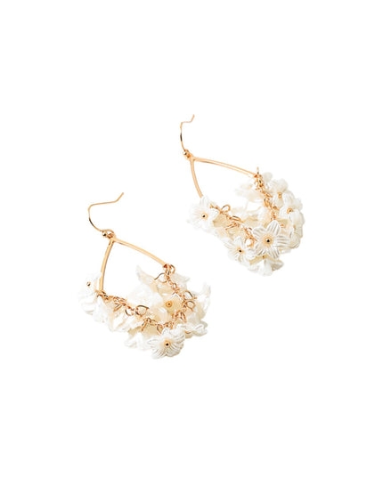 A pair of gold-tone hoop earrings adorned with clusters of small white daisy flowers, shown on a plain white background.
