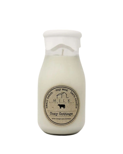 Milk bottle-shaped candle labeled 'Cozy Cottage' on a white background