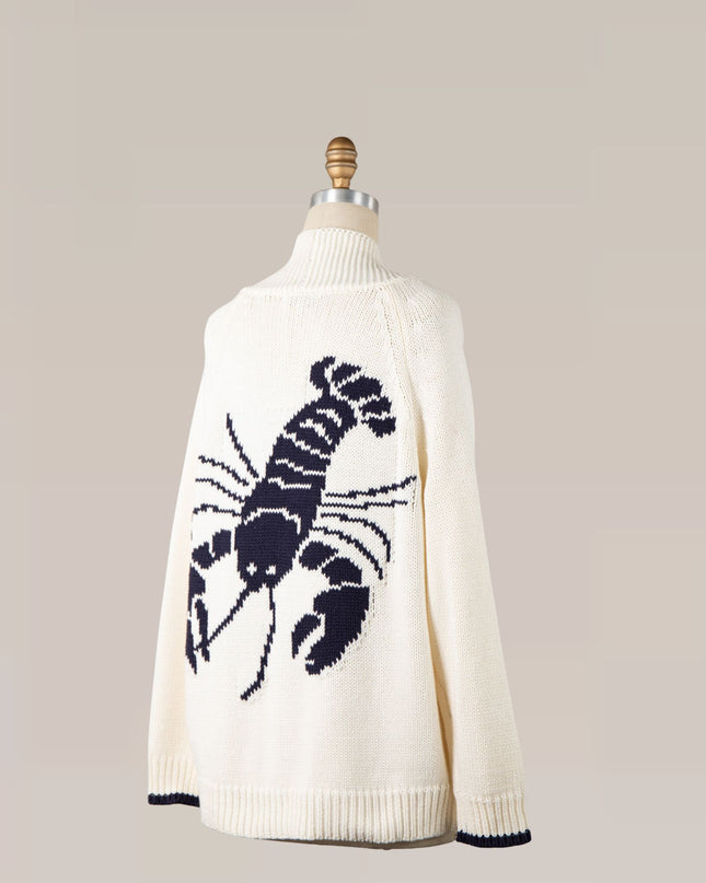 White sweater with a black lobster design on a mannequin against a beige background