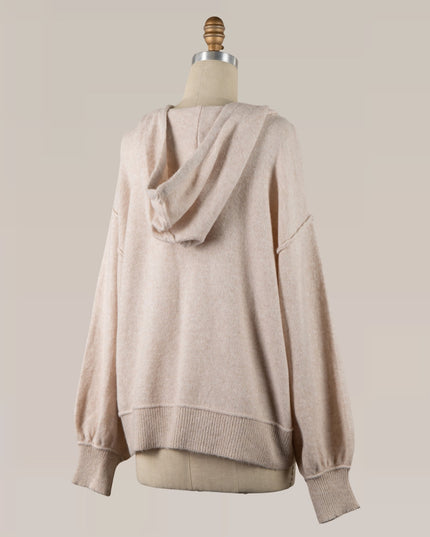 A light beige knit hoodie sweater displayed on a dress form mannequin against a solid light beige background.