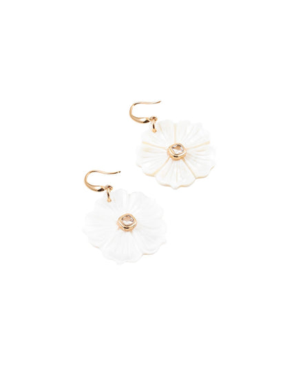 A pair of white flower-shaped drop earrings with gold-tone hooks and a small clear rhinestone in the center, shown on a plain white background.