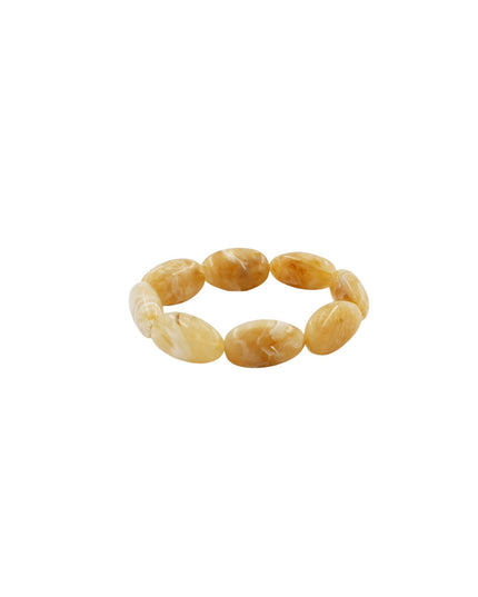A beaded stretch bracelet made of smooth, polished oval beads in a warm honey-gold and amber color, shown on a plain white background.