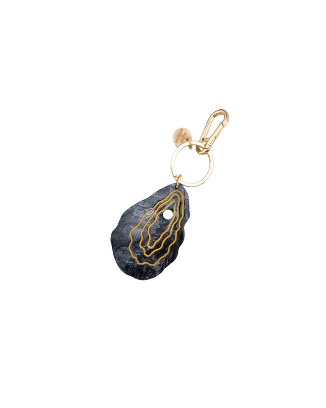 A black agate oyster pendant keychain with gold-colored concentric lines and a gold lobster clasp, shown on a plain white background.