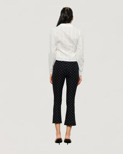 Person wearing a pink top and black riding pants on a white background