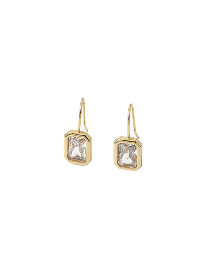 Silver earring with three green gemstones on a white background