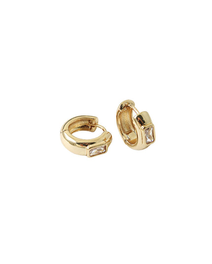 A pair of gold huggie hoop earrings with small rectangular clear gemstones, shown on a plain white background.