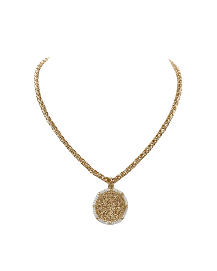 A gold chain necklace with a circular pendant featuring a textured gold center and a border of small clear stones, displayed on a solid white background.