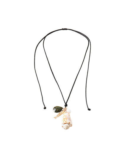 A double-strand black cord necklace featuring a whimsical pendant with a small green leaf, a white shell, and a gold-toned charm shaped like a small figure, shown against a plain white background.