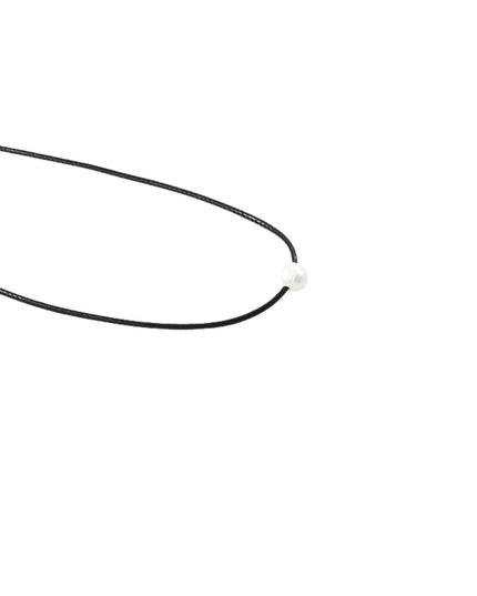 A minimalist black cord necklace with a small, round white bead or pearl accent, photographed on a seamless white background.