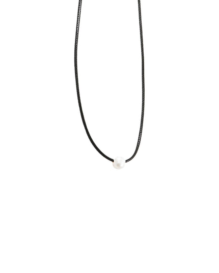 A minimalist black cord necklace with a small, smooth white bead at the center, shown against a solid white background.