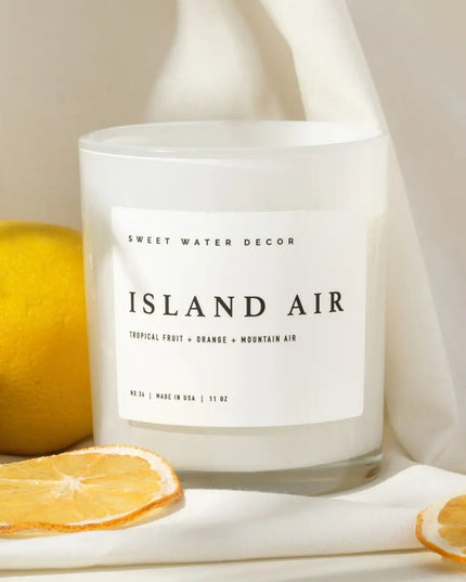 Candle labeled 'Island Air' with lemons and oranges on a light background