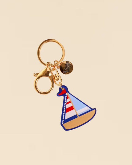 Keychain with sailboat design on a beige background