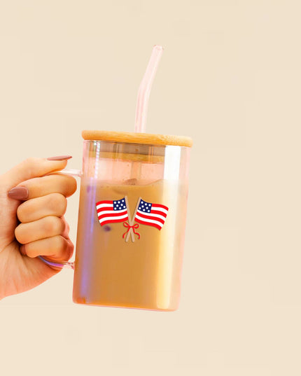 Hand holding a tumbler with American flags on a beige background