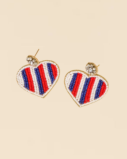 Heart-shaped earrings with red, white, and blue stripes on a beige background