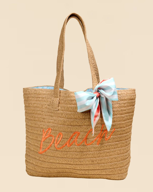 Woven beach bag with 'Beach' embroidery and a ribbon on a beige background