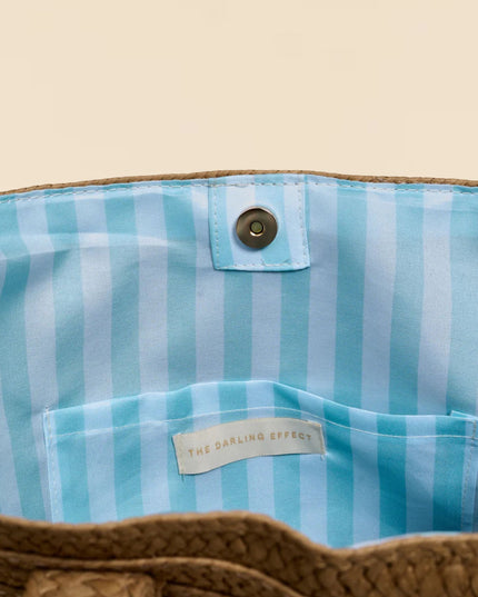 Close-up of a blue striped fabric with a brand label on a beige background