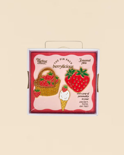 Pack of strawberry-themed pins with a decorative box on a beige background