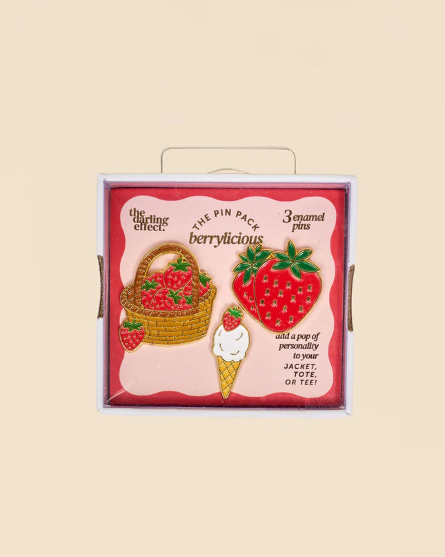 Pack of strawberry-themed pins with a decorative box on a beige background
