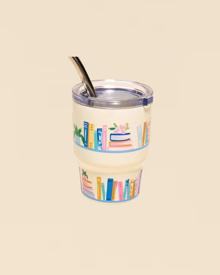 Clear tumbler with colorful book design on a beige background