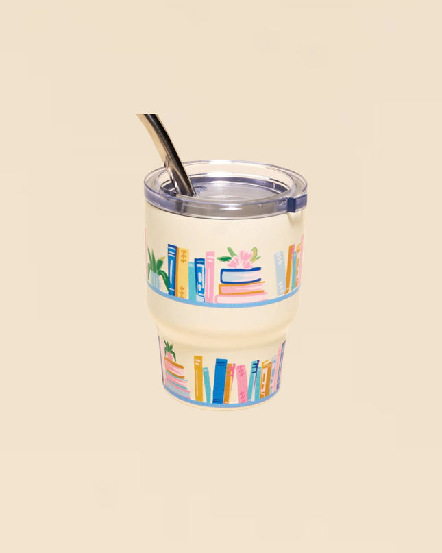 Clear tumbler with colorful book design on a beige background