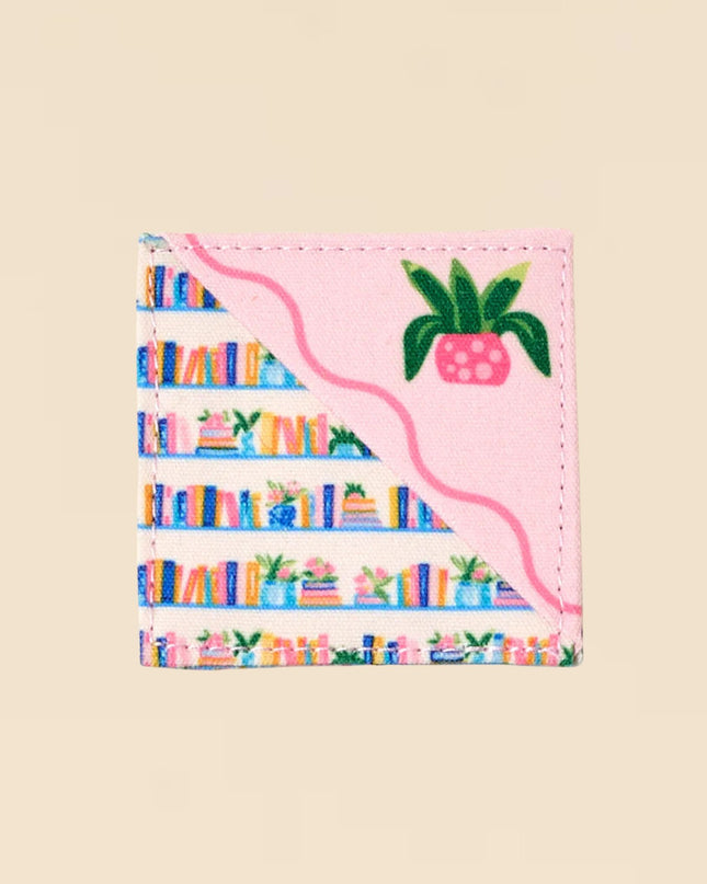 Small pouch with colorful book design and pink pineapple on a beige background
