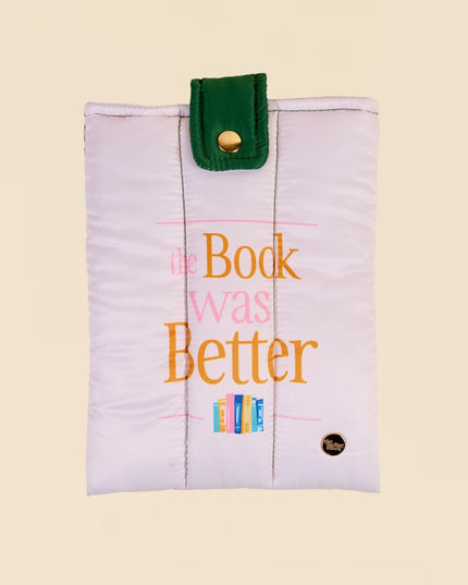 White pouch with colorful text and green strap on a beige background