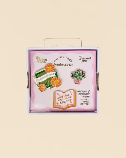 Box of 'bookworm' pins with decorative elements on a beige background