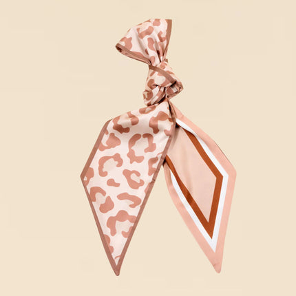 Leopard print scarf tied in a knot on a beige background
