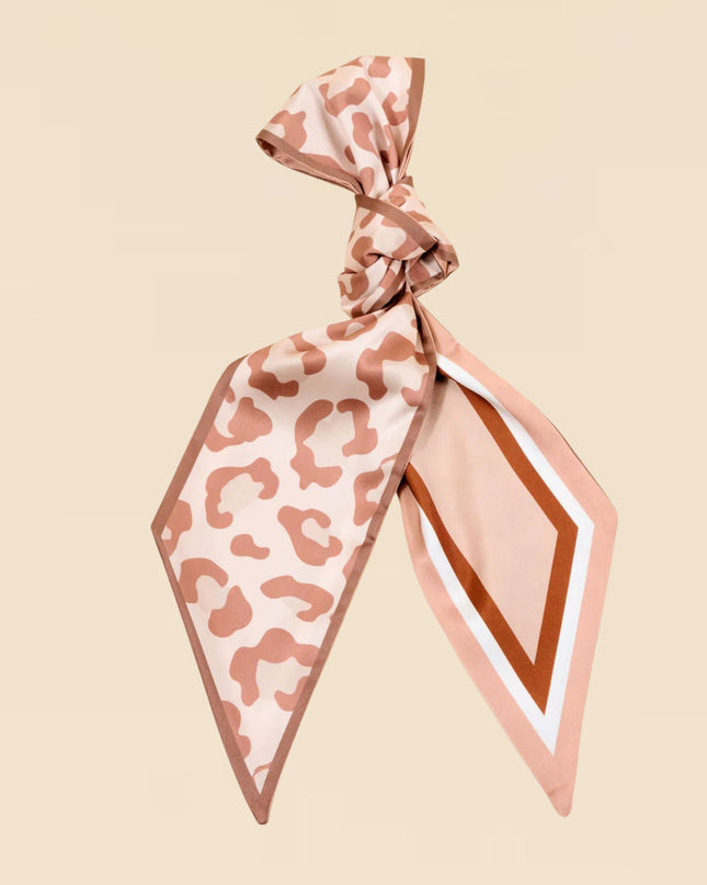 Leopard print scarf tied in a knot on a beige background