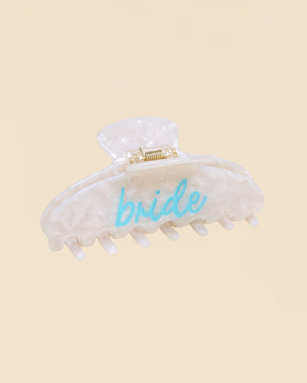 White hair clip with 'bride' text on a beige background