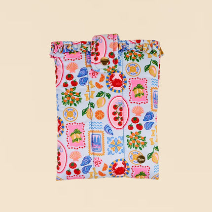 Colorful patterned bag with fruits and vegetables on a beige background