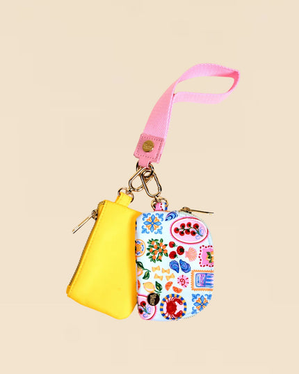 Yellow pouch with floral patterned tag on a beige background