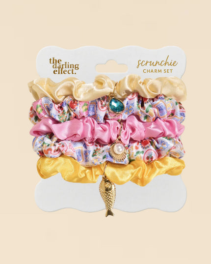 Colorful scrunchie charm set on a beige background with 'the darling effect' branding.