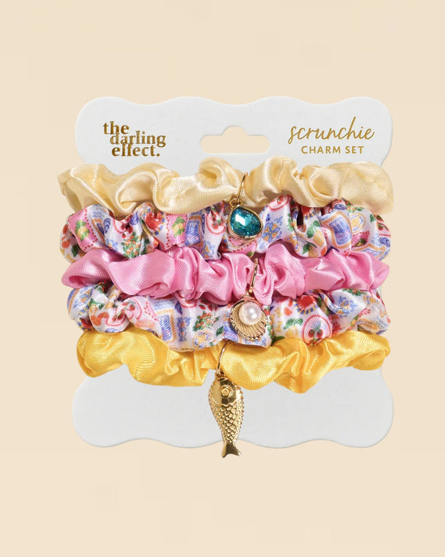 Colorful scrunchie charm set on a beige background with 'the darling effect' branding.