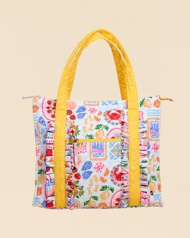 Colorful patterned tote bag with yellow handles on a beige background