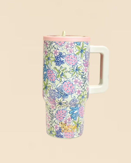 Floral-patterned tumbler with a white handle on a beige background