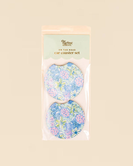Set of floral car coasters in packaging on a beige background