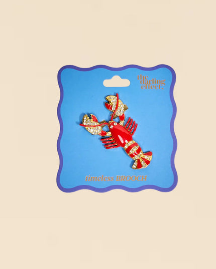 Decorative lobster-shaped item on a blue card with 'the lobster effect' branding on a beige background.